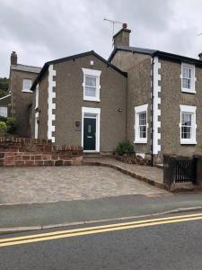 a brick house with a green door on a street at The Cottage, amazing views, pet friendly in Heswall