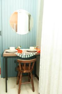 a dining room table with a mirror and a chair at HOSPEDAGEM CASA COMPACTA in Jaraguá do Sul