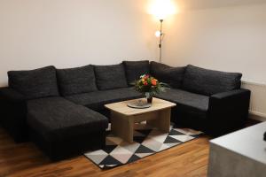 a living room with a black couch and a table at Ferienwohnung am Herzplatz in Memmelsdorf