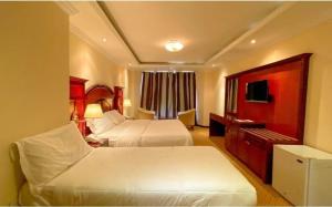 una camera d'albergo con due letti e un pianoforte di Regal Peninsula Hotel Formerly New Peninsula Hotel Ghubaiba Bus Station Bur Dubai a Dubai