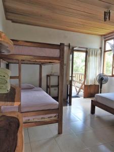 a bedroom with two bunk beds and a balcony at Quinta El Mamey in Río Verde