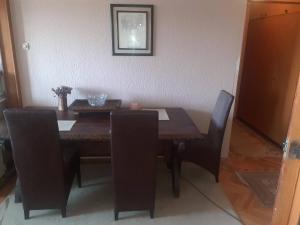 a dining room table with black chairs and a wooden table at NIKOLIĆ APARTMAN in Vranje