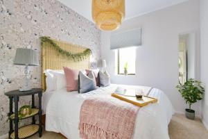 Un dormitorio con una cama blanca con almohadas rosas y blancas en Luxury Spacious 2 bed Apartment en Shilton