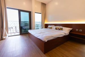 a bedroom with a bed and a large window at Horizon Villa in Qurayyah