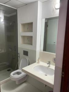 La salle de bains est pourvue d'un lavabo, de toilettes et d'un miroir. dans l'établissement Royal Nest Premium, à Pune