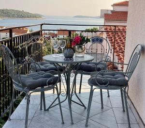 a table and chairs on a balcony with a view of the water at Apartmani Mate in Rogoznica