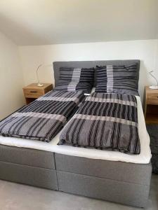 a bed with two striped pillows on top of it at Ferienwohnung Louis in Passau