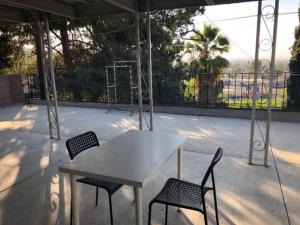 - une table blanche et 2 chaises sur la terrasse dans l'établissement Cosy & Peaceful Place in LA, à Hacienda Heights