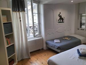 ein kleines Schlafzimmer mit 2 Betten und einem Fenster in der Unterkunft La maison des remparts in Falaise