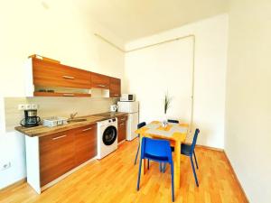 een keuken met een houten tafel en blauwe stoelen bij Central Spacious Flat in Boedapest