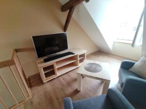 a living room with a tv and a couch at Schmal & Hoch - Willkommen im schmalsten Haus von Bad Frankenhausen in Bad Frankenhausen