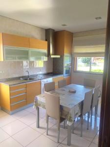 a kitchen with a table and chairs and a sink at Bela moradia T3, solarenga e espaçosa 
