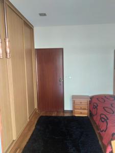 a bedroom with a bed and a dresser and a door at Bela moradia T3, solarenga e espaçosa 