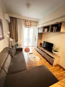 ein Wohnzimmer mit einem Sofa und einem Tisch in der Unterkunft Irene's cozy apartment in Volos