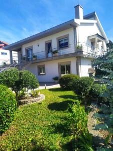 una gran casa blanca con un patio de césped en Bela moradia T3, solarenga e espaçosa, 