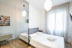 a white bedroom with a bed and a mirror at Easylife - Luminosa oasi di relax a Porta Romana in Milan