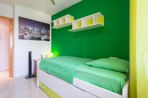 マラガにあるSUNBURN, Aquí Hay Quíen Vivaの緑の壁に囲まれたベッドルーム(ベッド1台、棚付)