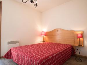 a bedroom with a red bed with two lamps at Appartement Lanslevillard, 3 pièces, 5 personnes - FR-1-508-139 in Lanslevillard