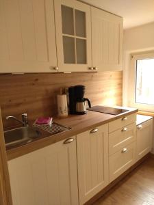 a kitchen with white cabinets and a sink at Schmal & Hoch - Willkommen im schmalsten Haus von Bad Frankenhausen in Bad Frankenhausen