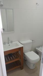 a white bathroom with a toilet and a sink at Monoambiente centrico in Gualeguaychú