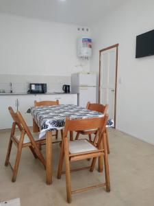 a table and chairs in a kitchen with a table and a refrigerator at Monoambiente centrico in Gualeguaychú