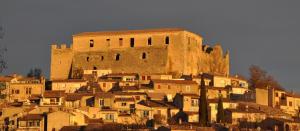 een groot kasteel bovenop een stad bij Studio meublé avec terrasse in Gréoux-les-Bains