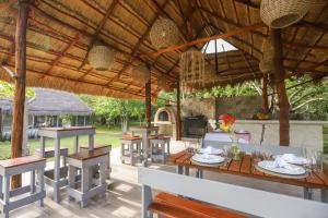 una zona de comedor con mesas y sillas bajo un pabellón en Mayan Secret Hotel Boutique, en Chetumal