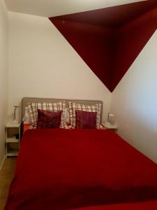 een slaapkamer met een rood bed en een rode deken bij CrisAnd 3 Panoramic in Altenau