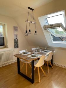 ein Esszimmer mit einem Tisch, Stühlen und einem Fenster in der Unterkunft Nordlicht in Wilhelmshaven