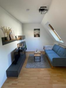 ein Wohnzimmer mit einem blauen Sofa und einem Tisch in der Unterkunft Nordlicht in Wilhelmshaven