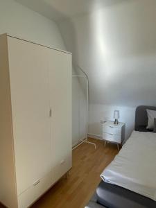 ein Schlafzimmer mit einem weißen Schrank und einem Bett in der Unterkunft Nordlicht in Wilhelmshaven