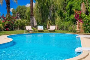 una grande piscina con due sedie di Gaia Residences with lush garden and pool ad Argostoli