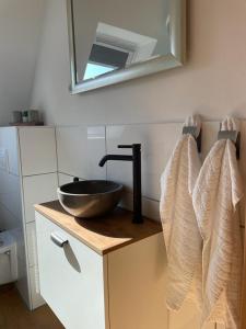 a bathroom with a sink and a mirror and towels at Nordlicht in Wilhelmshaven +26 photos