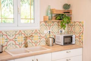 a kitchen with a sink and a microwave on a counter at Gaia Residences with lush garden and pool in Argostoli