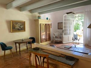ein Wohnzimmer mit einem Tisch und einem Esszimmer in der Unterkunft Mas Antonine Cigalle in Arles