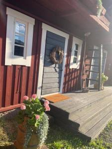 uma porta da frente de uma casa com uma coroa de flores na porta em Suloinen luhtirakennus Randla em Rauma