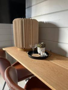 uma mesa de madeira com um prato e copos sobre ela em Suloinen luhtirakennus Randla em Rauma