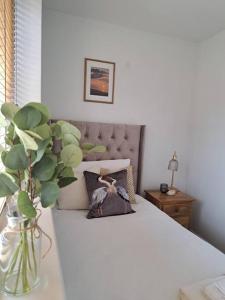 sypialnia z łóżkiem oraz waza z rośliną w obiekcie Beachwood House, Serviced Accommodation w mieście Brumby