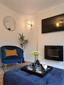 a living room with a blue couch and a blue chair at Beachwood House, Serviced Accommodation in Brumby