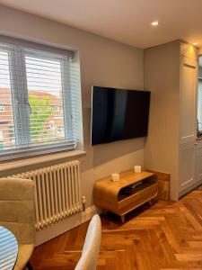 a living room with a flat screen tv on the wall at A luxury brand-new apartment in Barnet