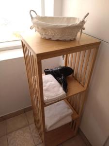 a wooden shelf with towels and a basket on it at Schmal & Hoch - Willkommen im schmalsten Haus von Bad Frankenhausen in Bad Frankenhausen