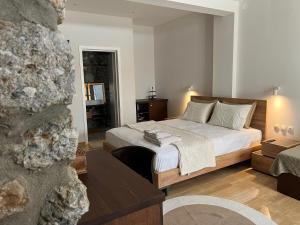 a bedroom with a bed and a living room at Olympus Stone Lodge in Litochoro