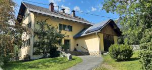a large yellow house with a solar roof at Ferienwohnung im alten Zollhaus in Dellach
