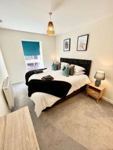 a bedroom with a large bed and a window at Modern spacious 2 bed Apartment, close to Gunwharf Quays & Historic Dockyard - Balcony, Smart Tv, Free Parking, WiFi, Double or single beds in Portsmouth