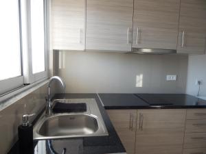 a kitchen with a sink and wooden cabinets at Bel Air Rooms in Himare +38 photos