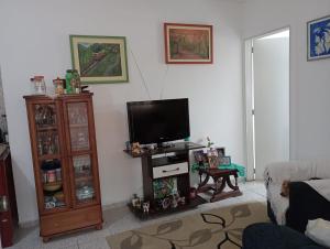 a living room with a flat screen tv and a table at Casa para temporada - Campos do Jordão in Campos do Jordão