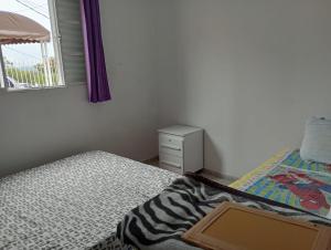 a small bedroom with a bed and a window at Casa para temporada - Campos do Jordão in Campos do Jordão