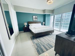 a bedroom with blue walls and a bed and a tv at Sun&Sea IconBrickell Unit in Miami