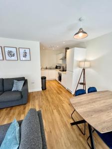 a living room with a couch and a table at Modern spacious 2 bed Apartment, close to Gunwharf Quays & Historic Dockyard - Balcony, Smart Tv, Free Parking, WiFi, Double or single beds in Portsmouth