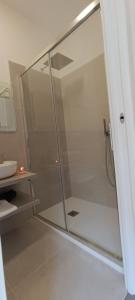 een glazen douche in een badkamer met een wastafel bij A Casa Nostra B&B in Cagliari